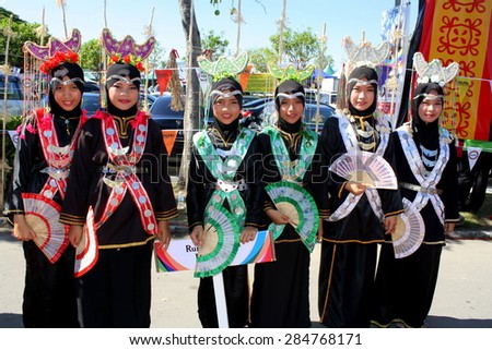 KOTA KINABALU, MALAYSIA - MAY 30, 2015: Young women of Kadazandusun ethnic in their traditional costumes pose for guests during the State Harvest Festival Celebration in KDCA, Kota Kinabalu, Sabah.