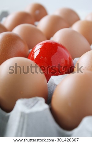 Eggs in a tray and one egg red in color. Easter theme egg