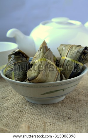 Zong zi is a traditional Chinese food, made of glutinous rice stuffed with different fillings and wrapped in bamboo, reed, or other large flat leaves. They are cooked by steaming or boiling.