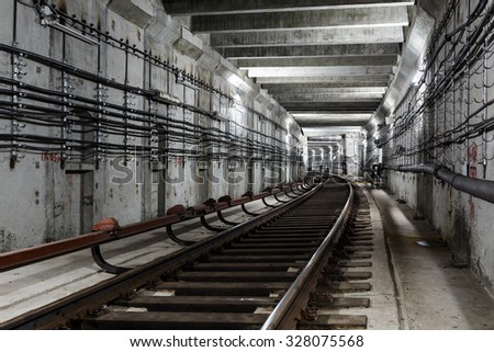 rectangular subway tunnel with a turn to the left and white lighting