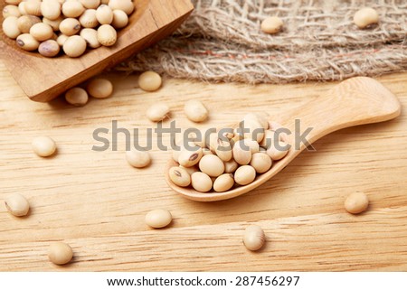 dry soybeans in wooden spoon on table
