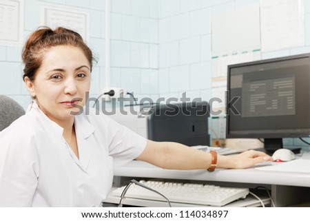 Middle-aged caucasian female doctor at computer desk