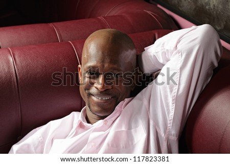 Smiling middle-aged guy laying down on sofa closeup