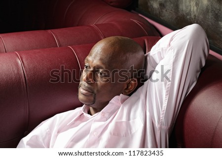 Pensive middle-aged guy laying down on sofa closeup