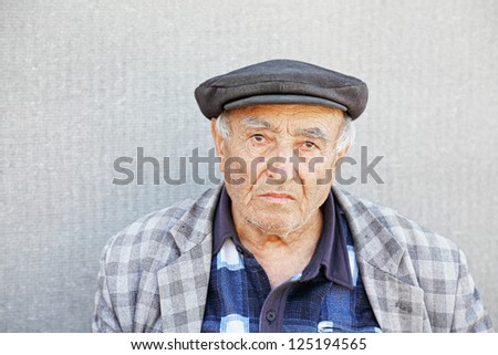 Senior man in checkered jacket and cap closeup photo