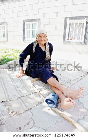 Senior woman sitting on the ground at backyard enjoying sun