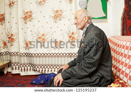 Senior serene man on sofa looking sideways