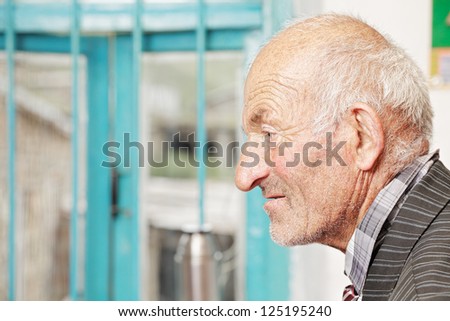 Profile view of senior man sitting against window