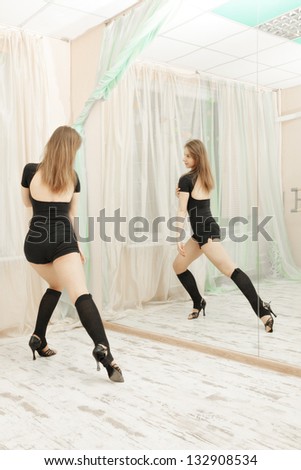 Dance instructor making exercises against mirror
