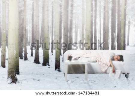 Young woman having nap on sofa in winter forest