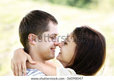 Pretty couple touching nose to nose outdoor closeup photo