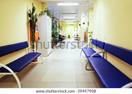 Blue benches at yellow walls in fitness center corridor