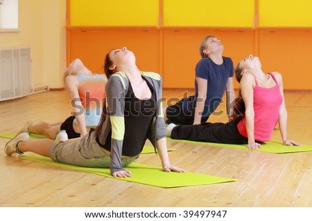 Group bending backs at aerobics training in gym selective focus
