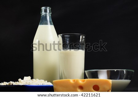 Various dairy products in line against dark background