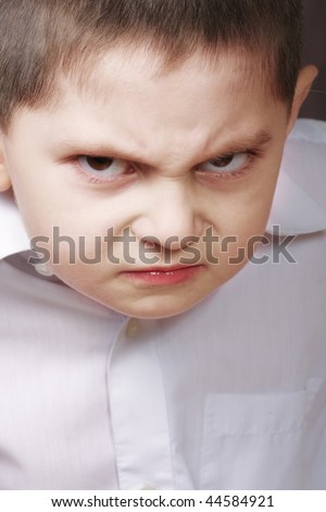 Little boy with angry facial expression closeup photo