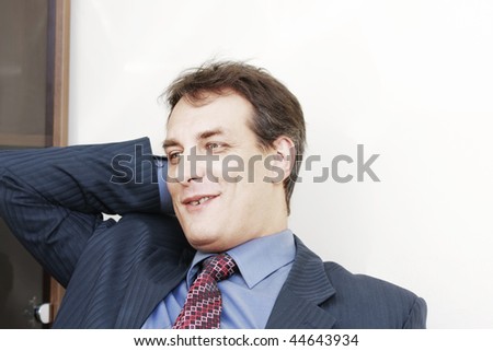 Smiling businessman in formal wear scratching head looking aside