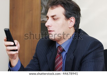 Businessman in formal wear dialing number on phone
