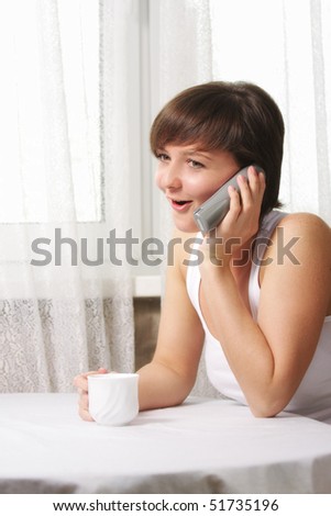 Young brunette housewife has lively phone talk