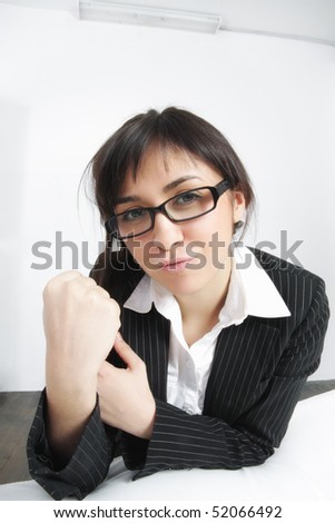 Pretty young businesswoman showing fist in threat gesture