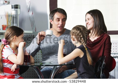 Dad tells story to family sitting in cafe at table