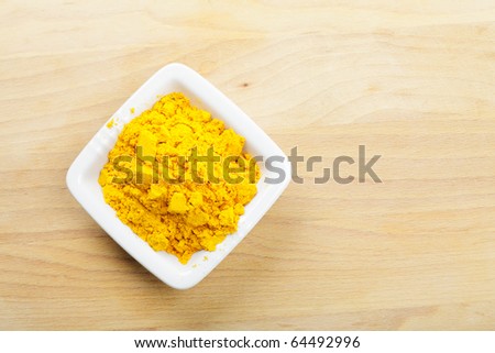 Saffron spice in white dish on wooden board above view
