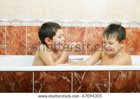Two brothers having foam battle while taking bath