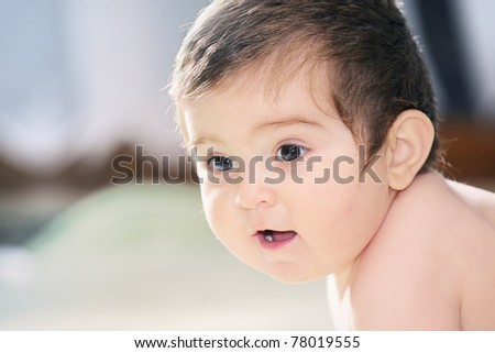 Cute baby indoors looking sideways
