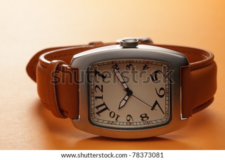 Wristwatch with leather strap over brown