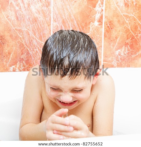 Little boy taking shower in bathroom