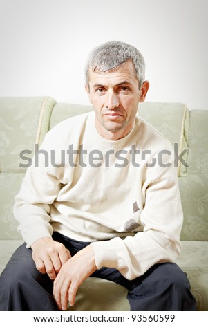 Guy sitting on sofa bending forward