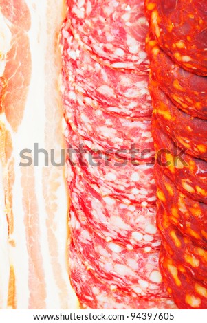 Various sliced meat products in rows closeup photo