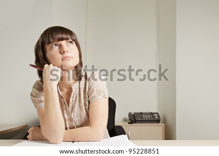 Young brunette woman at desk looking up