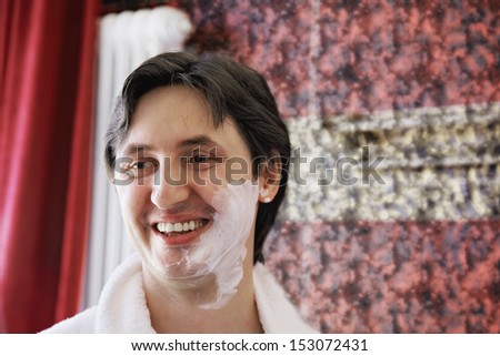 Happy guy with shaving foam on face
