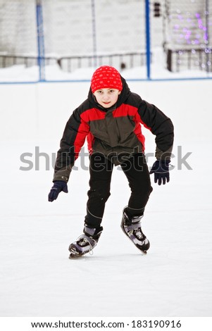 Kid enjoying skating on the ice rink outdoors