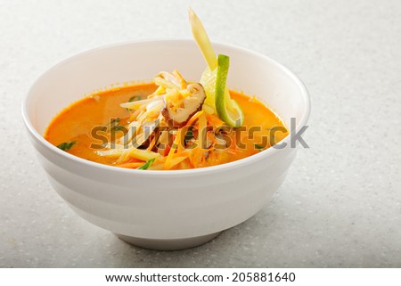 Plate of traditional spicy and sour Thai and Lao soup Tom Yam closeup photo