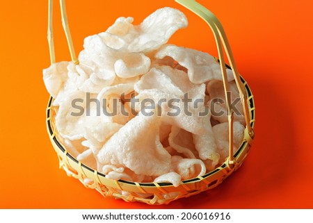 Shrimp chips in a basket over the orange tabletop