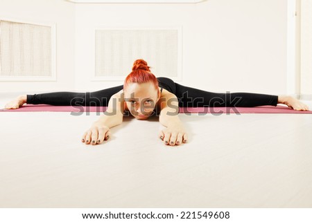 Redhead exercising yoga laying down on floor legs stretched