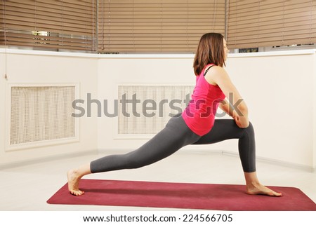 Brunette looking sideways exercising stretching yoga pose