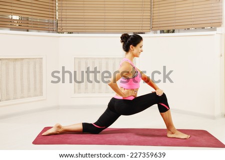 Contented brunette woman at stretching yoga pose