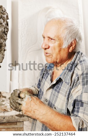Portrait of elderly sculptor in studio