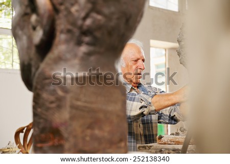 Looking behind the statues at the working sculptor