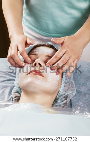 Masseuse making face massage to middle-aged caucasian woman