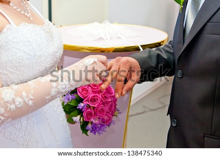 The bride wears a wedding ring to the groom
