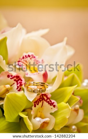Wedding rings on a bouquet of orchids