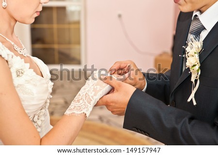 groom newlyweds wears ring bride at a wedding couple