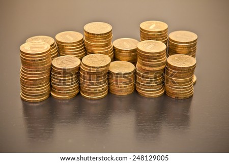 stack of coins on a black wooden background, shallow depth of field