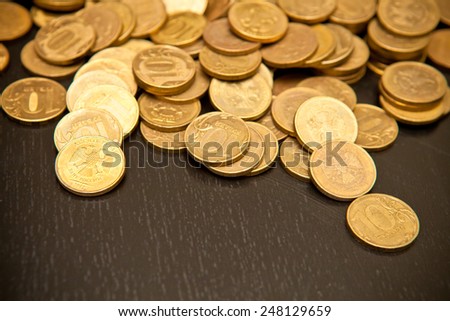 scattering of coins on a black wooden background, shallow depth of field
