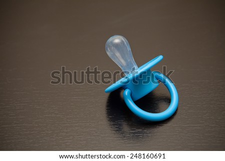 pacifier nipple on a black wooden background