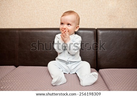 child in a blue suit sitting on a sofa