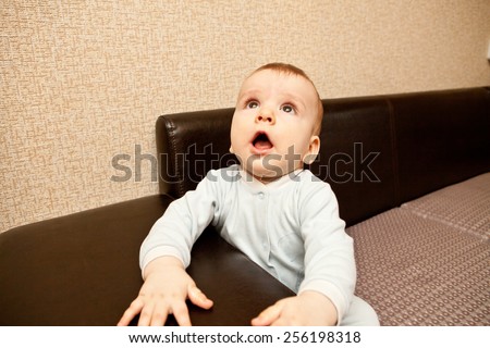 child in a blue suit sitting on a sofa